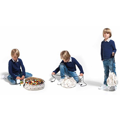 Drie afbeeldingen van een jongen die speelt met bouwblokken op een play&go opbergzak, deze sluit en vervolgens draagt.
