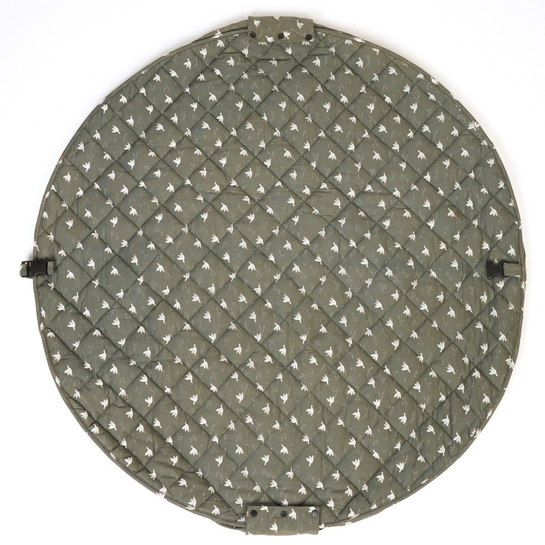 play&go rond baby speelkleed met groen-wit vogelpatroon, plat op de grond met gespen zichtbaar.