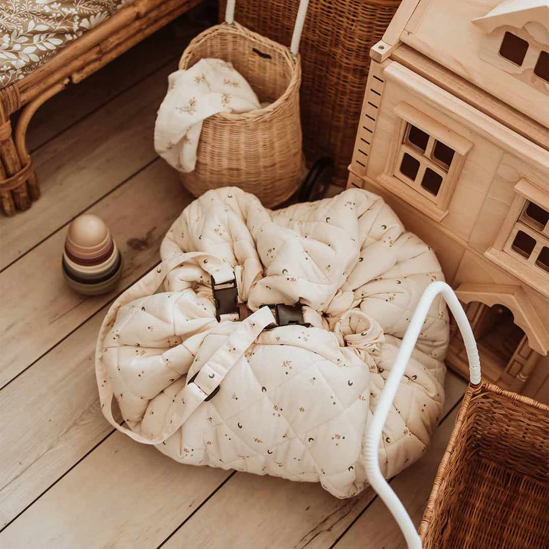 Het play&go babyspeelkleed is samengebonden tot een draagtas met speelgoed ernaast.