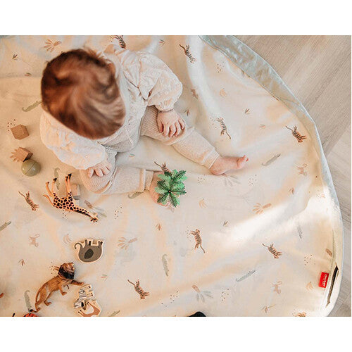 Een baby speelt op het play&go speelkleed met jungleprint en speelgoeddieren.