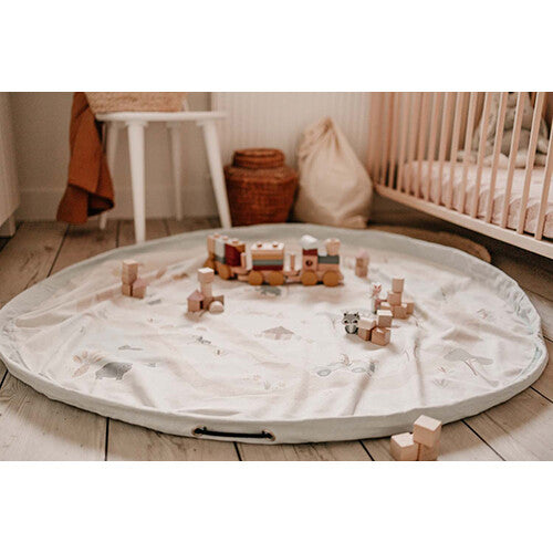 play&go speelkleed met jungleprint uitgevouwen op de vloer met houten speelgoed.