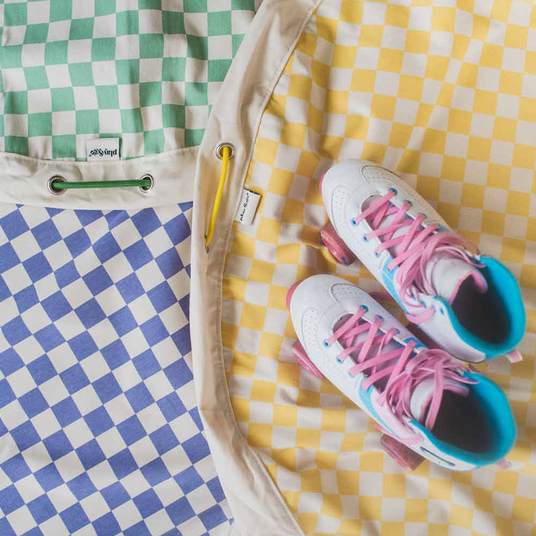 play&go geruite speelkleden in groen, blauw en geel met rolschaatsen erop.