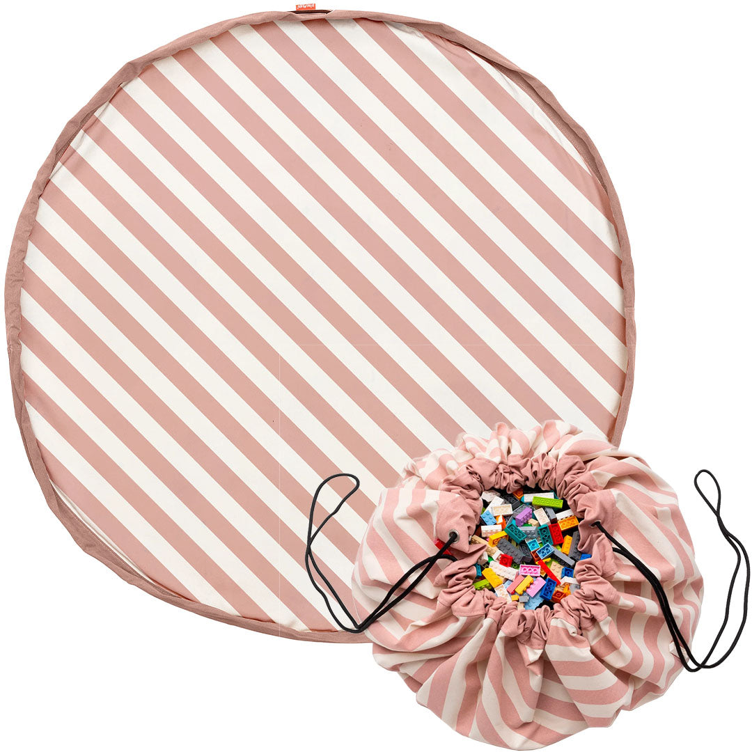 play&go speelkleed en opbergzak met roze en witte strepen, de opbergzak gevuld met speelgoed.