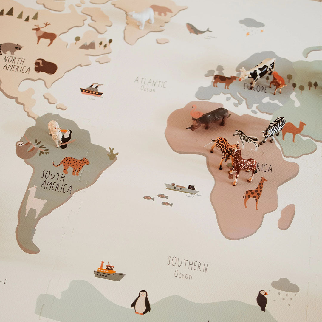 Detail van de play&go foam speelmat met wereldkaart, waarop kleine dierenfiguren op de continenten staan.