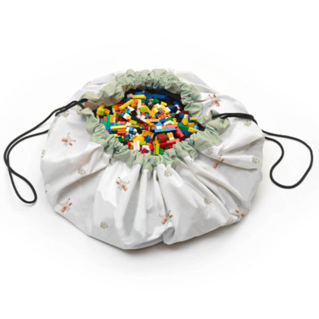 play&go speelkleed en opbergzak, deels dichtgetrokken en gevuld met kleurrijke bouwblokken.