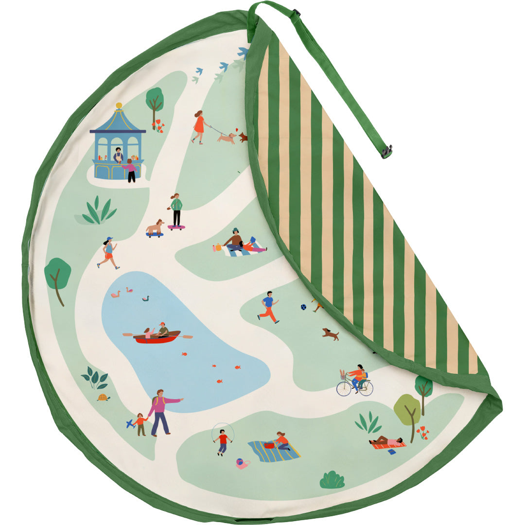 Rond play&go speelkleed met een parkthema, deels opgevouwen om de gestreepte achterkant te tonen.