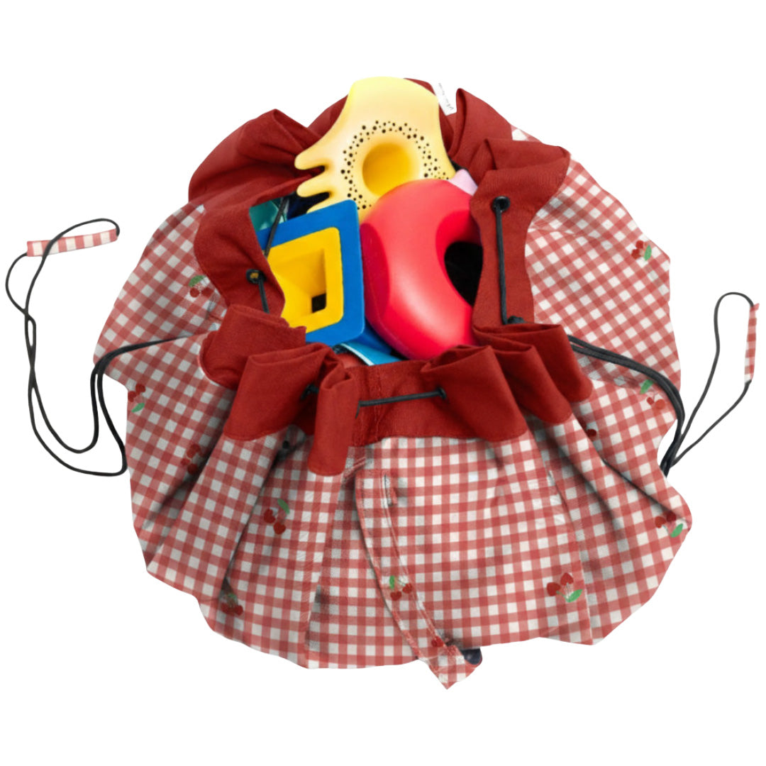 play&go opbergzak met rood-wit geruit patroon en kersenmotief, gevuld met speelgoed en dichtgetrokken.
