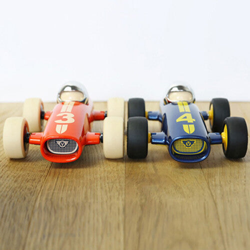 Twee Playforever raceauto's, een rode en een blauwe, staan naast elkaar op een houten ondergrond.