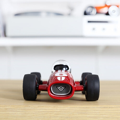 Playforever rode raceauto met nummer 6 staat recht van voren op een houten ondergrond.