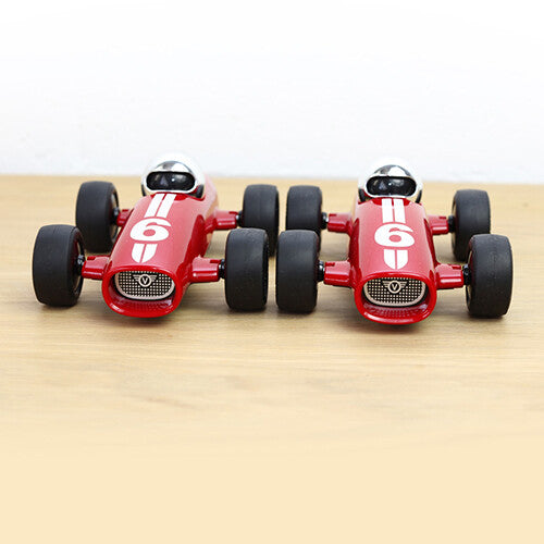 Twee identieke Playforever rode raceauto's met nummer 6 staan naast elkaar, recht van voren.