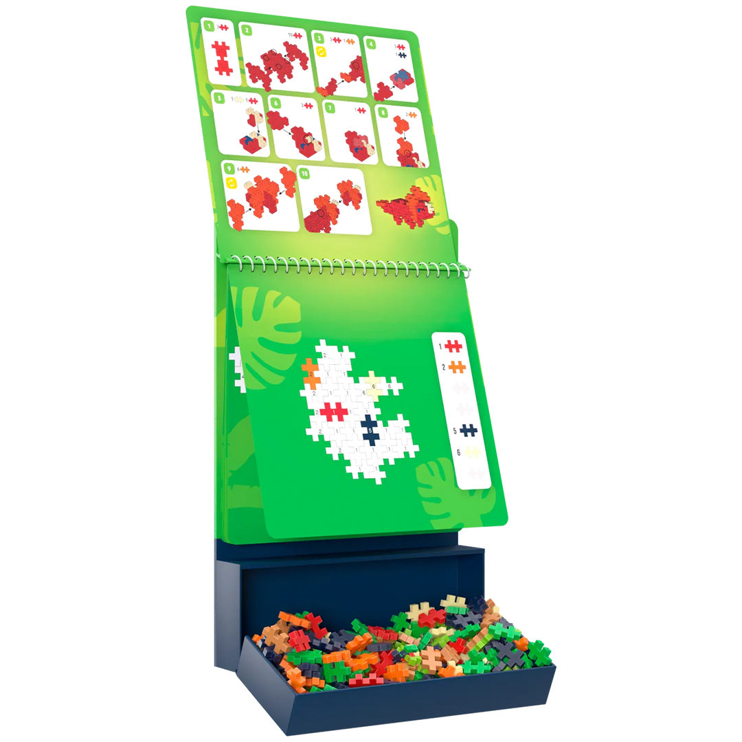Plus-Plus bouwblokken activity pad met instructies en een bakje vol gekleurde bouwblokken.
