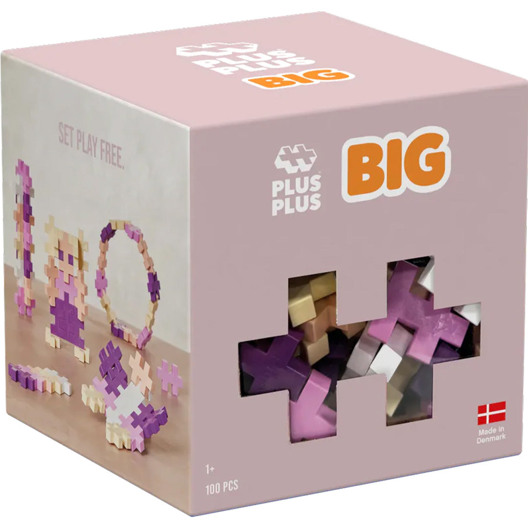 Plus-Plus BIG bouwblokken in een roze verpakking met venster, met de tekst '100 pcs' en '1+'.