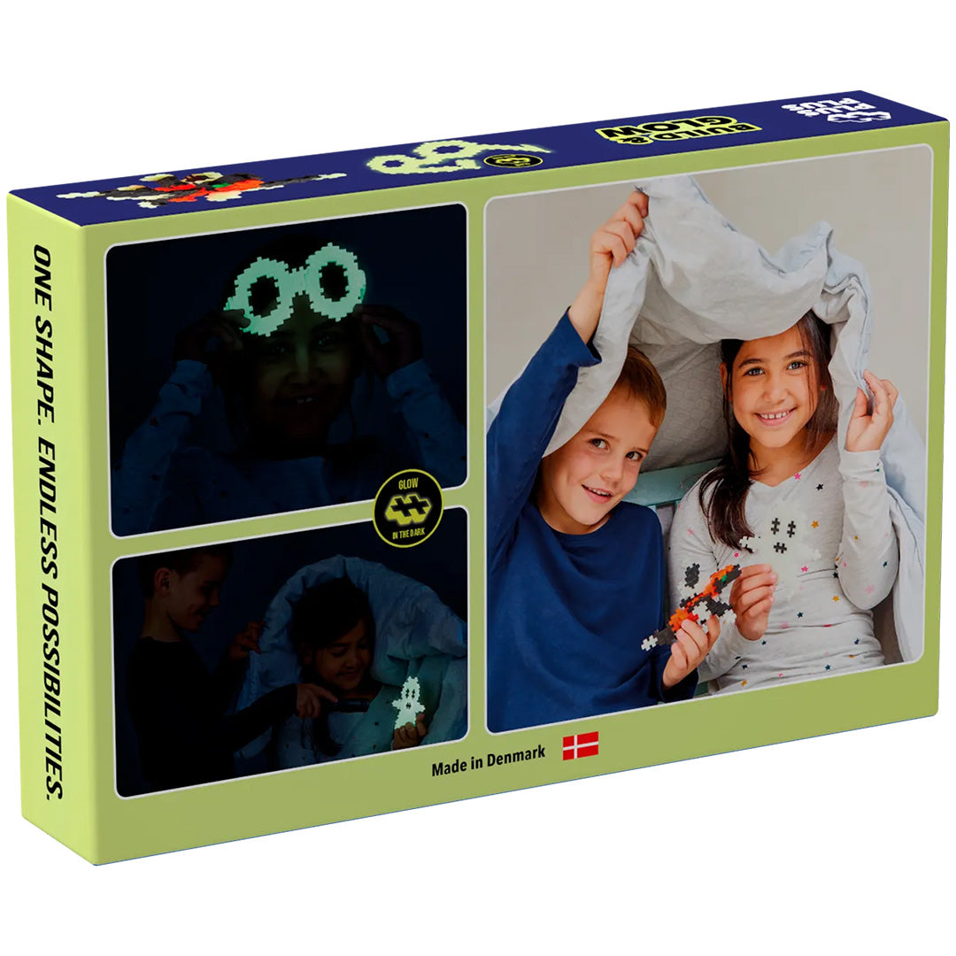 De verpakking van Plus-Plus Build & Glow bouwblokken met foto's van kinderen die spelen met de glow-in-the-dark creaties.