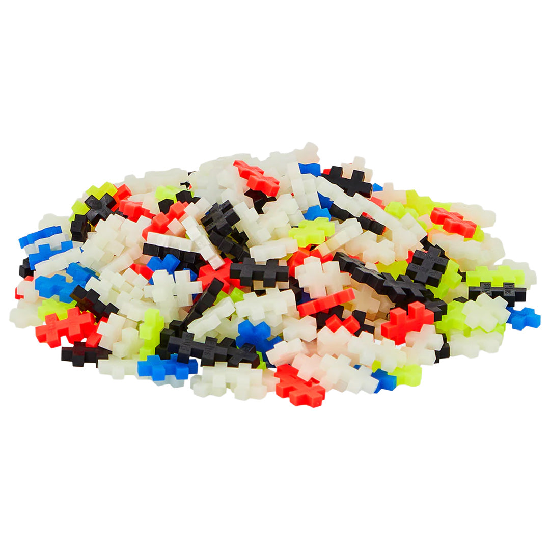 Een hoop losse Plus-Plus bouwblokken in verschillende kleuren, waaronder wit, rood, blauw, zwart en neongeel.