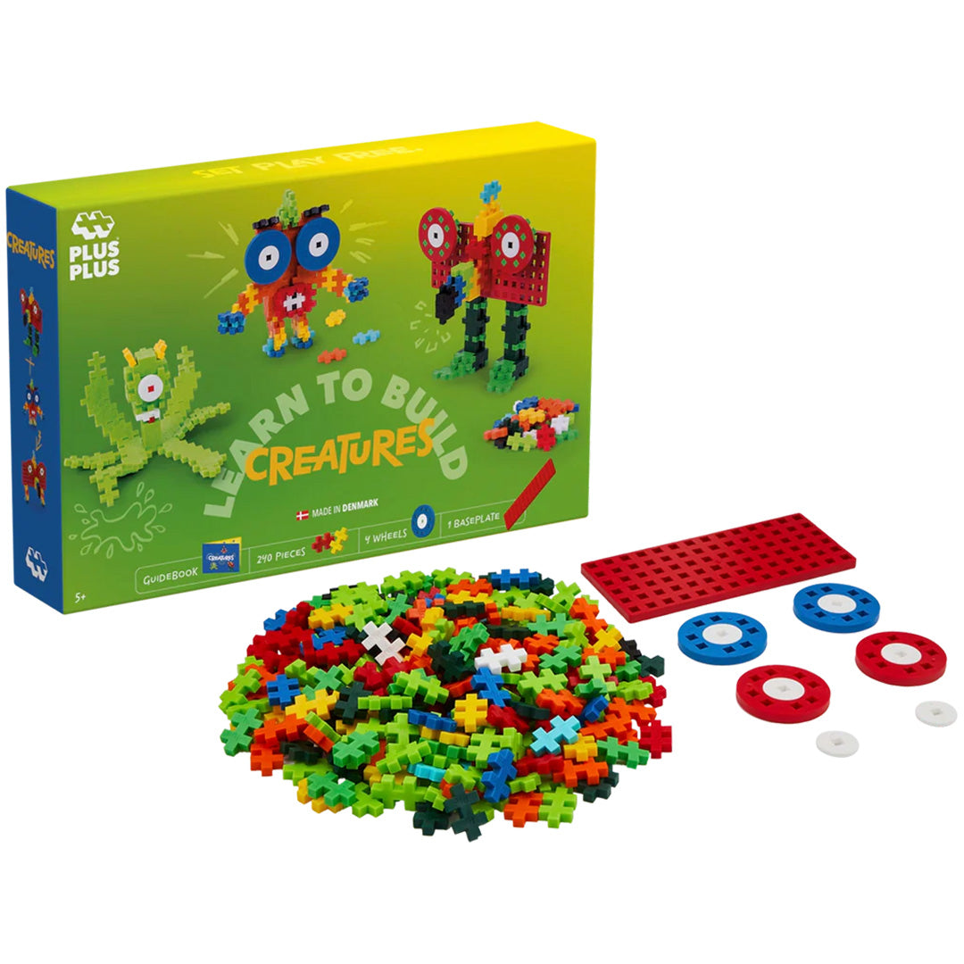 De Plus-Plus Learn to Build Creatures bouwset met verpakking, een berg bouwblokken, een rode bouwplaat en wielen.