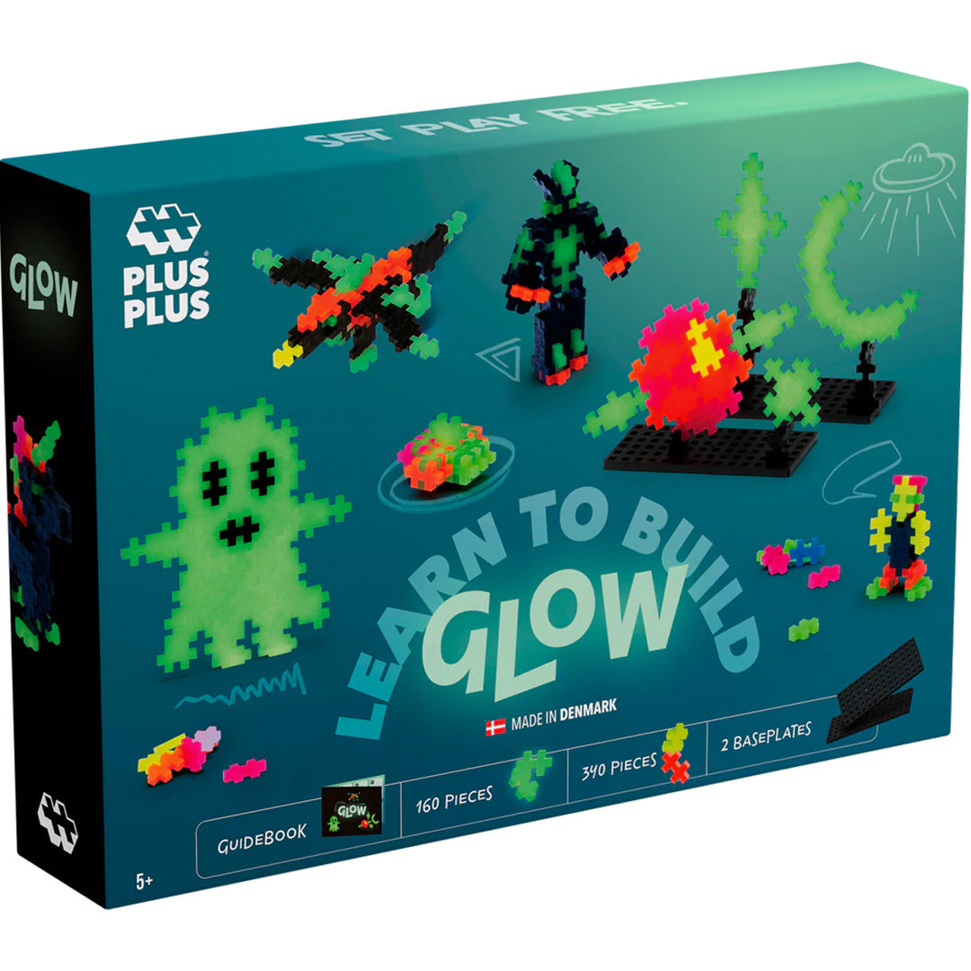 Verpakking van de Plus-Plus Learn to Build Glow bouwblokken set met voorbeelden van lichtgevende creaties.