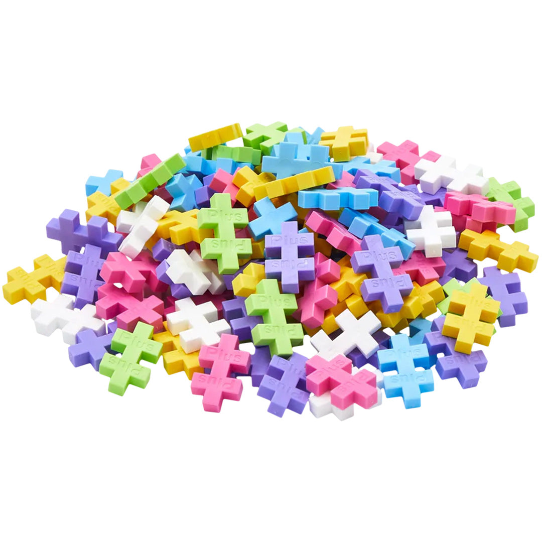 Een hoop losse Plus-Plus bouwblokken in diverse pastelkleuren.