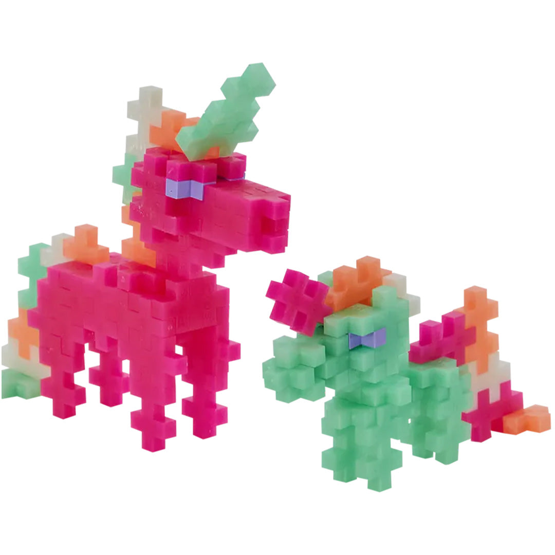 Twee Plus-Plus eenhoorns, een grote roze en een kleine groene, gemaakt van bouwblokjes tegen een witte achtergrond.