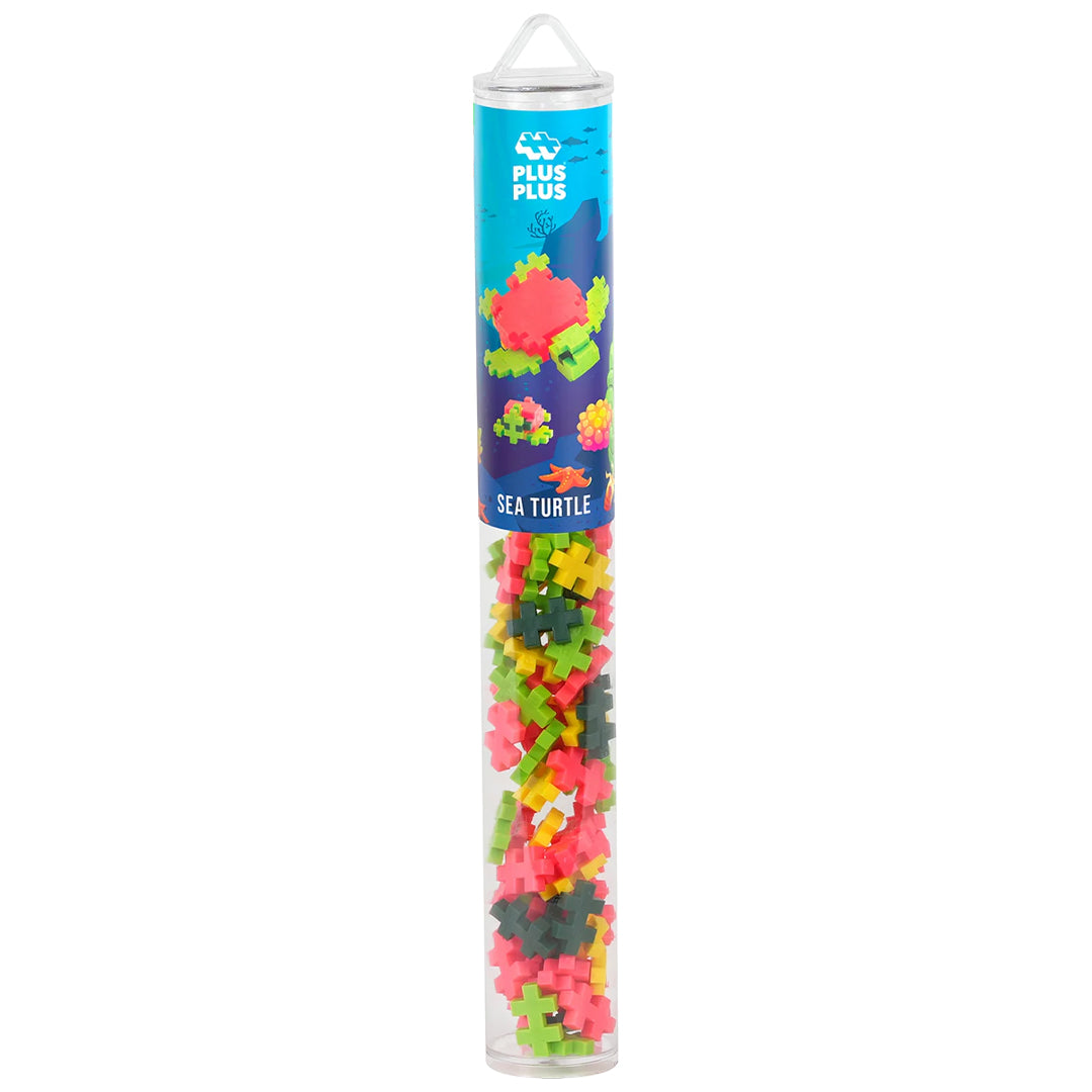 Plus-Plus bouwstenen Sea Turtle verpakking, een transparante koker met veelkleurige bouwblokjes.