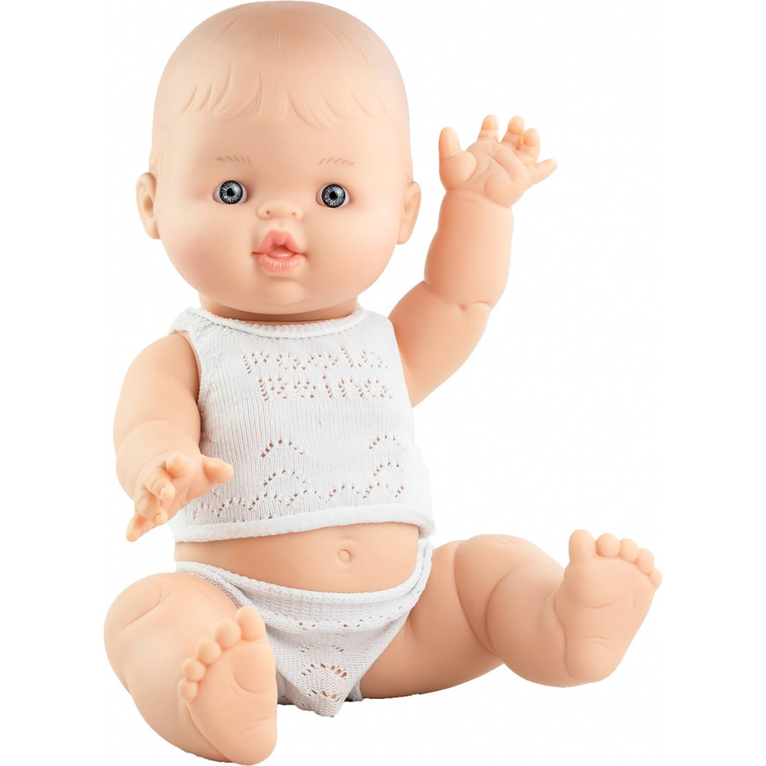Paola Reina Gordi babypop jongen met blauwe ogen en wit gebreid ondergoed, zittend.