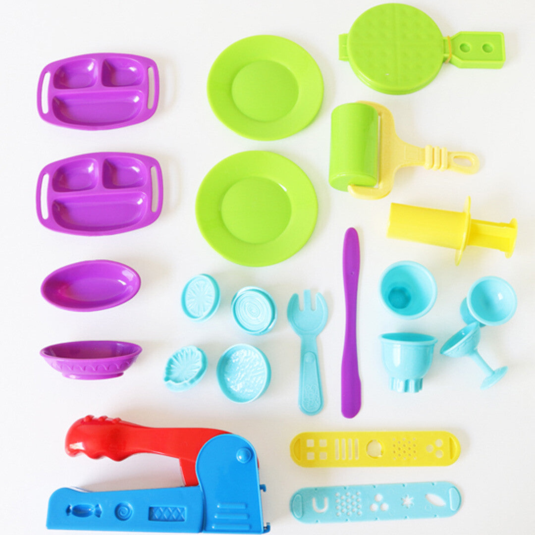 Bovenaanzicht van de Primo modelleerklei set accessoires, waaronder kleurrijke bordjes, een wafelijzer, een deegroller en diverse vormpjes.