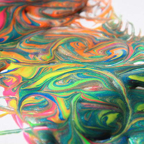 Een close-up van gemengde, wervelende Primo plakkaatverf in felle kleuren met glitters.