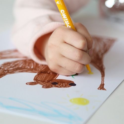 Een kinderhand tekent met een gele Primo viltstift een bruin dier en een gele zon op papier.