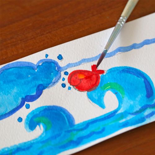 Een kwast schildert een rode vis in blauwe golven met waterverf.