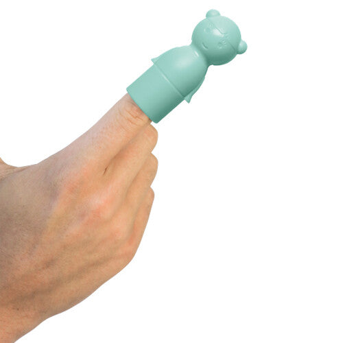 Een lichtgroen Quut badpuzzel peg-figuur als vingerpopje op een vinger.