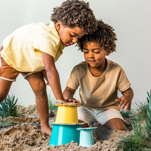 Twee kinderen spelen in het zand met de Quut zandstapeltoren alto.