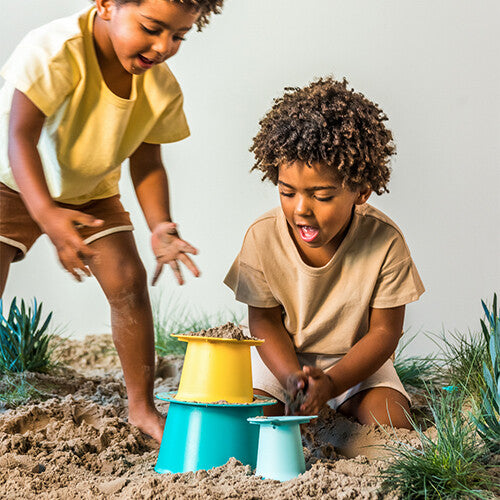 Twee kinderen spelen in het zand met de Quut zandstapeltoren alto.