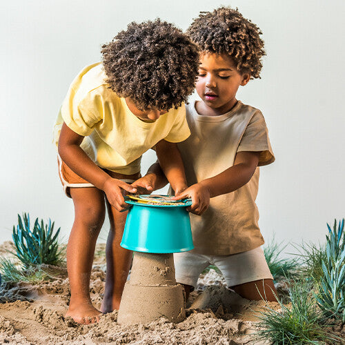 Twee kinderen maken een zandkasteel met de Quut zandstapeltoren alto.