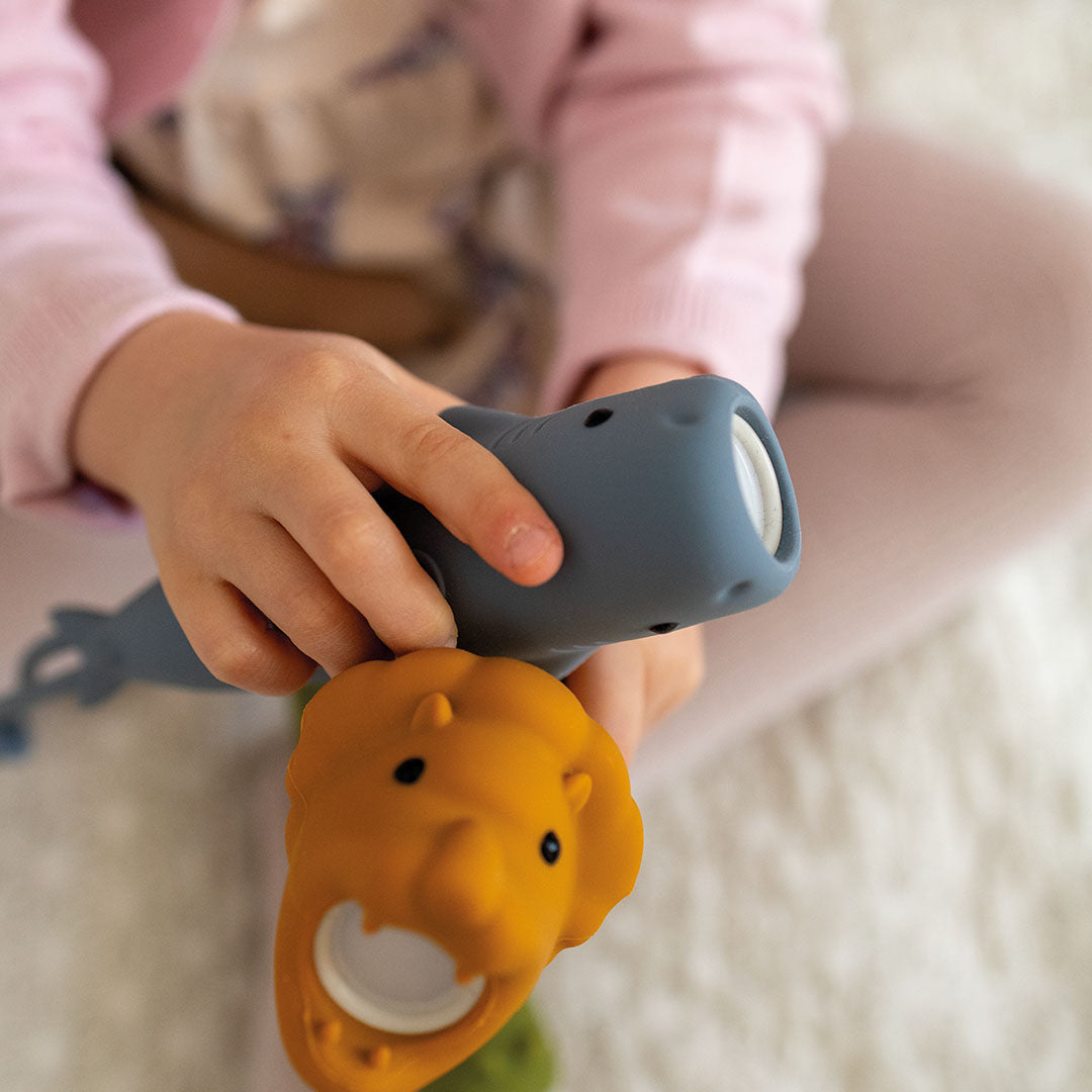 Een kind houdt de oranje leeuw zaklamp en een grijze dieren zaklamp vast.