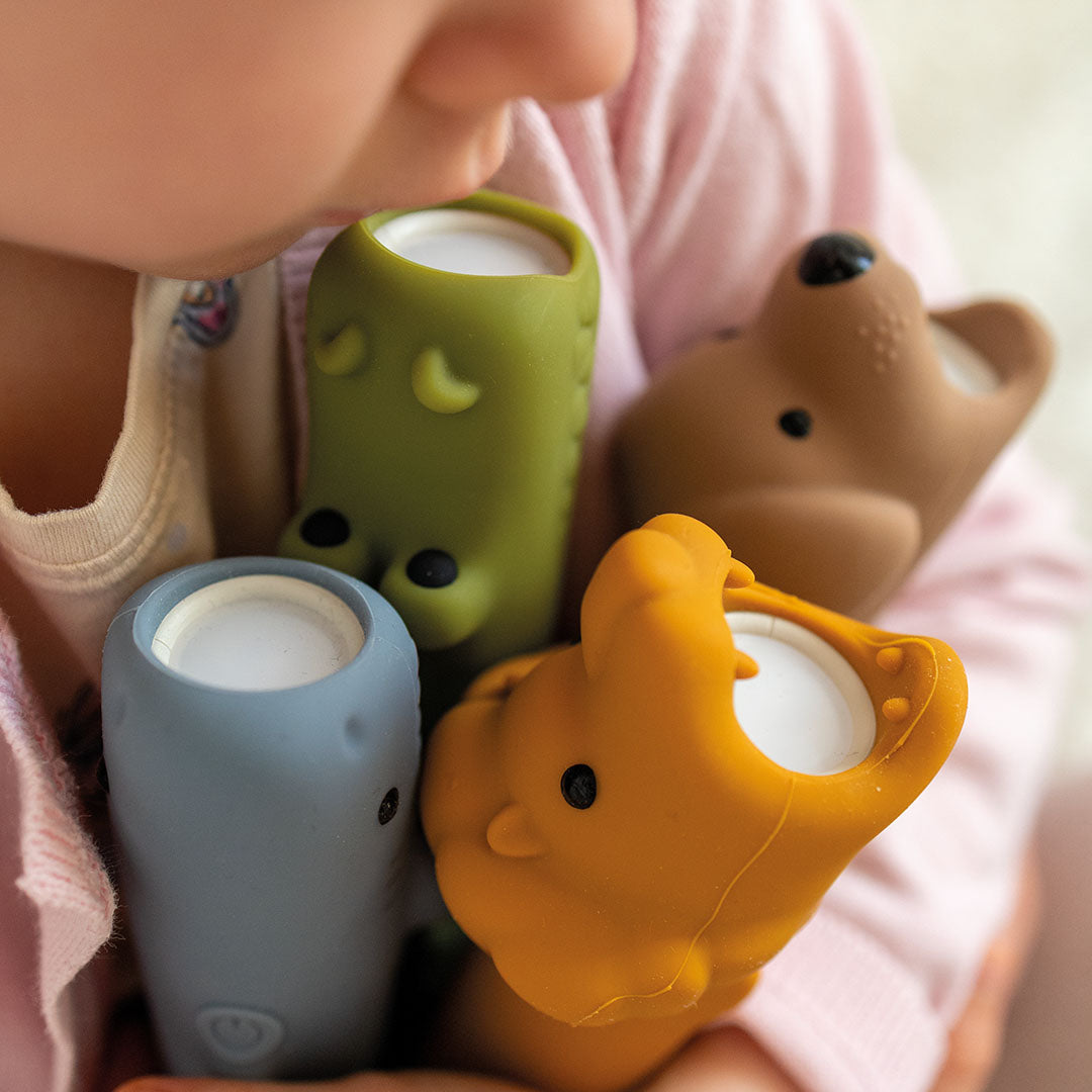 Een kind houdt een collectie van vier siliconen dieren zaklampen vast.