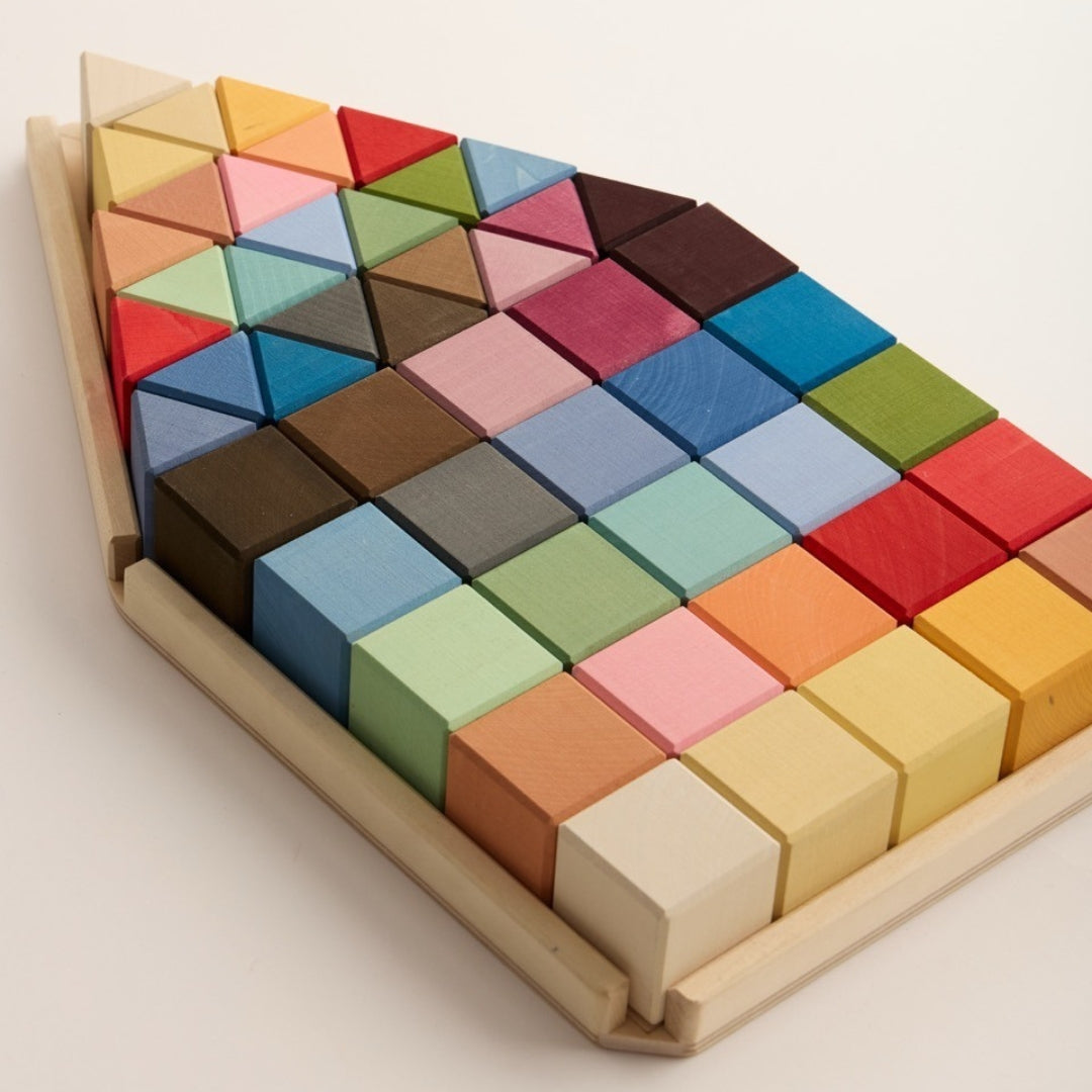 Raduga Grëz houten bouwblokken set schuin van bovenaf, gerangschikt in een huisvormige tray met veelkleurige blokken.