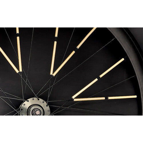 Detailopname van Rainette gouden spaakreflectoren bevestigd aan de spaken van een fietswiel.