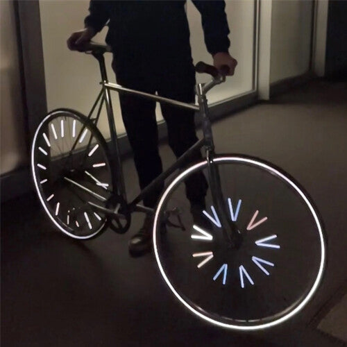 Een fiets in het donker met rainette spaakreflectoren die fel oplichten.