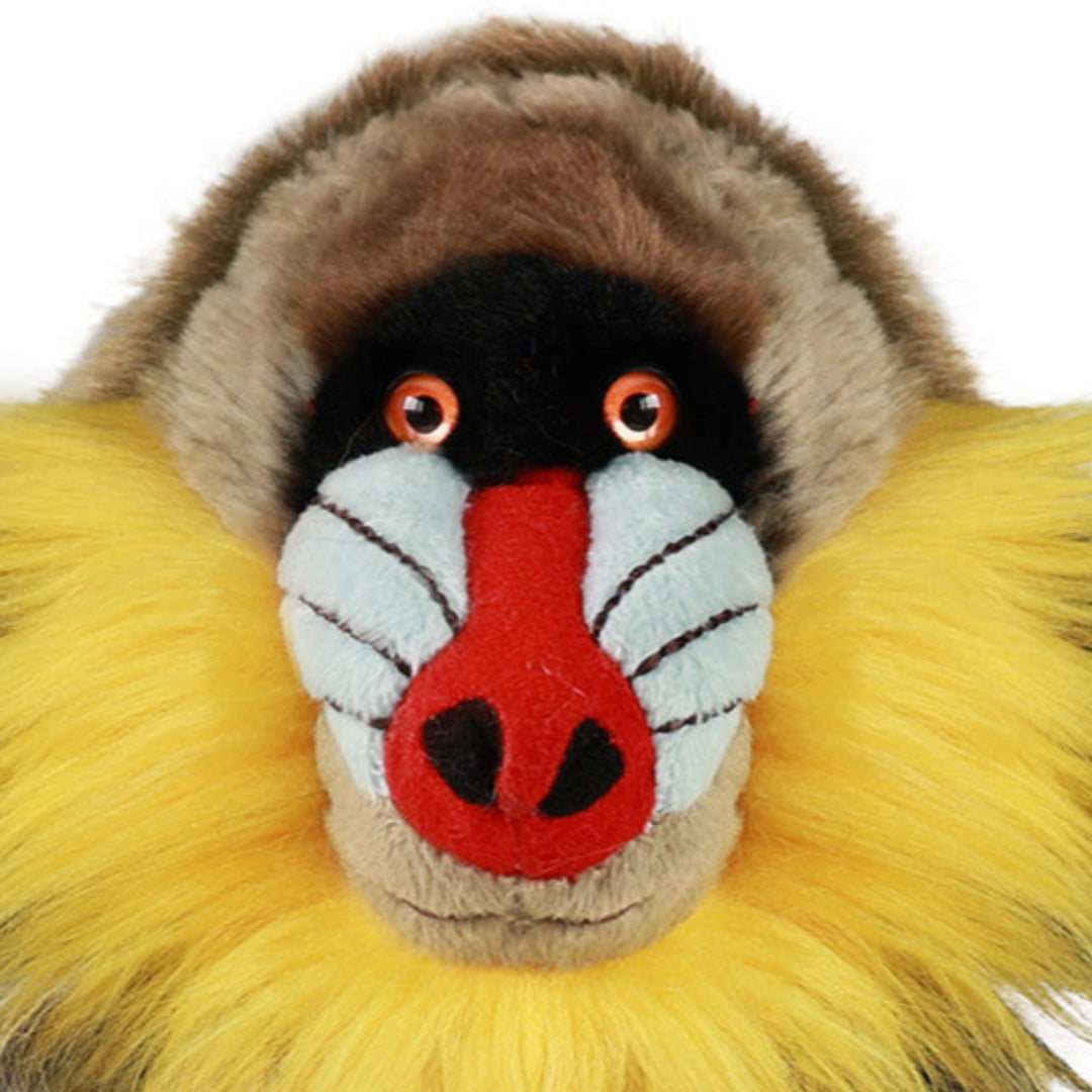 Close-up van het kleurrijke gezicht van de Rappa pluchen mandril knuffelaap met rode neus en gele manen.