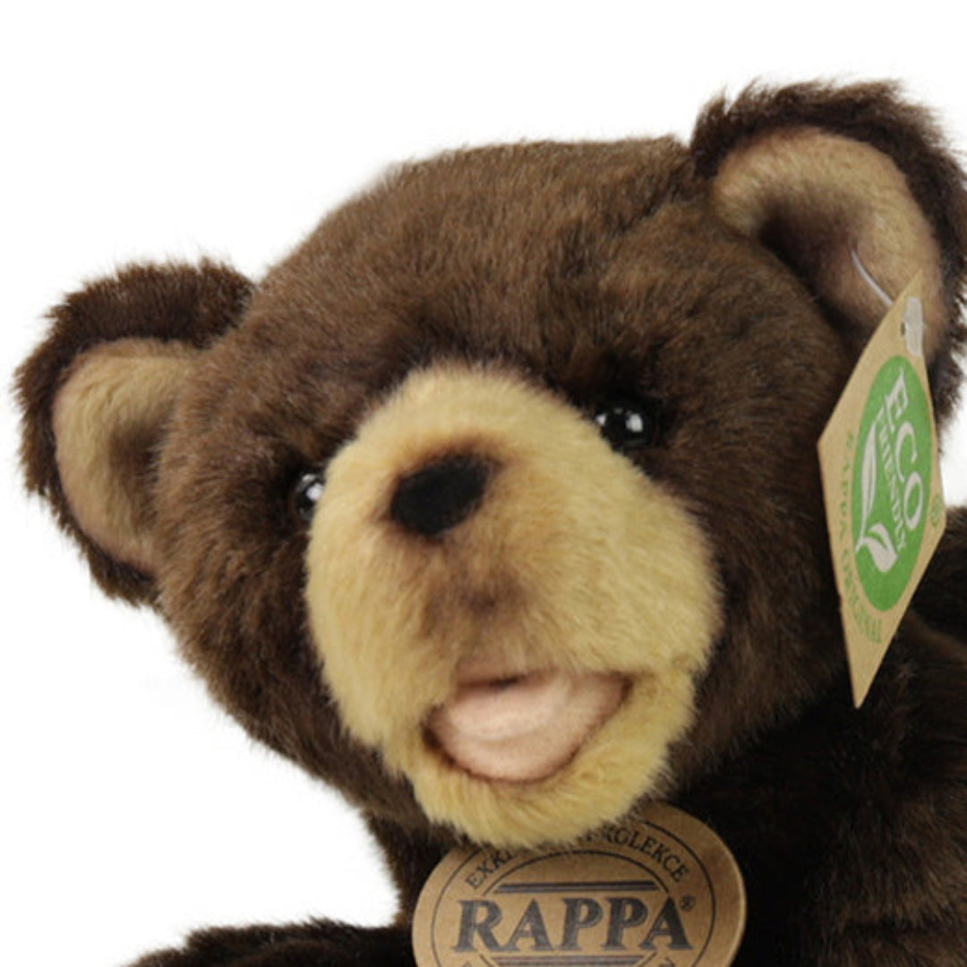 Detailopname van het gezicht van de Rappa knuffelbeer met open mond en labels.