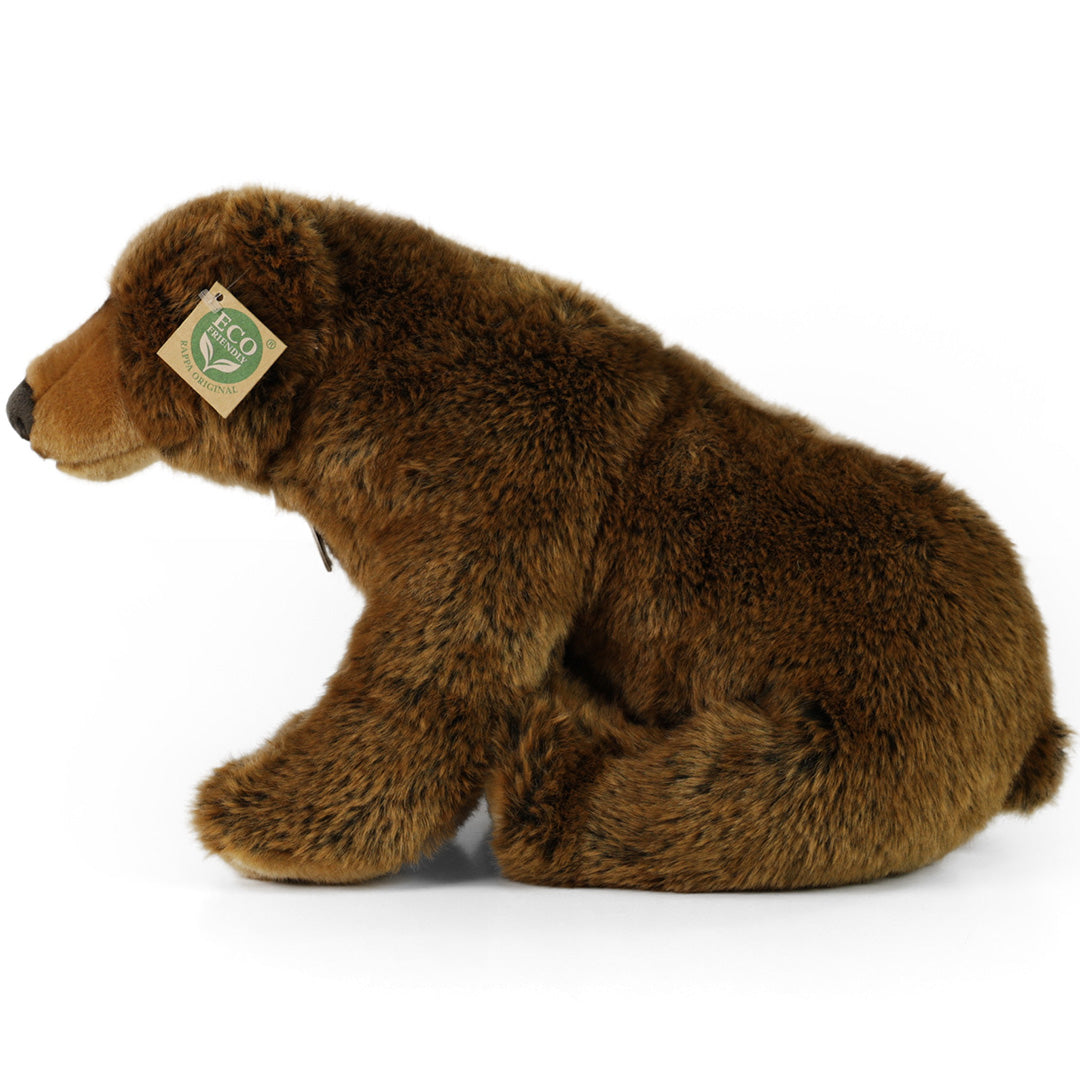 Rappa pluchen knuffelbeer in bruin, zittend en van de zijkant gefotografeerd.