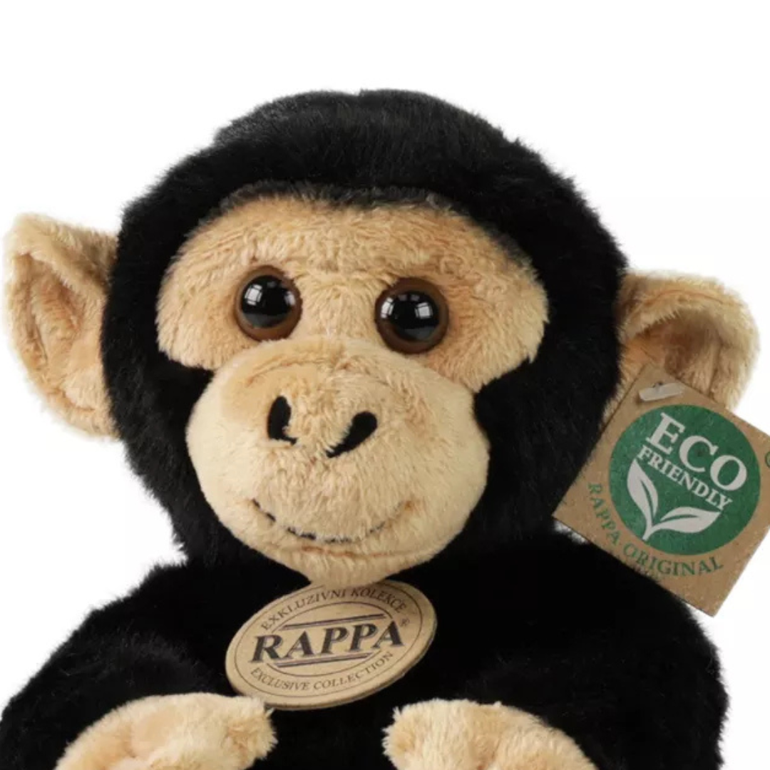 Detailopname van de kop en bovenkant van de Rappa pluchen chimpansee knuffel, met productlabels.