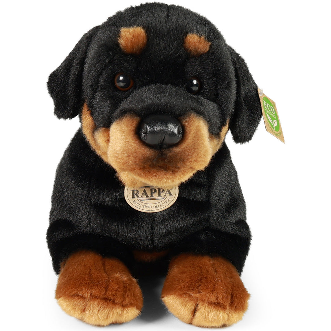 Rappa pluchen Rottweiler hond, zittend en recht van voren gefotografeerd, met merklabel op de borst.