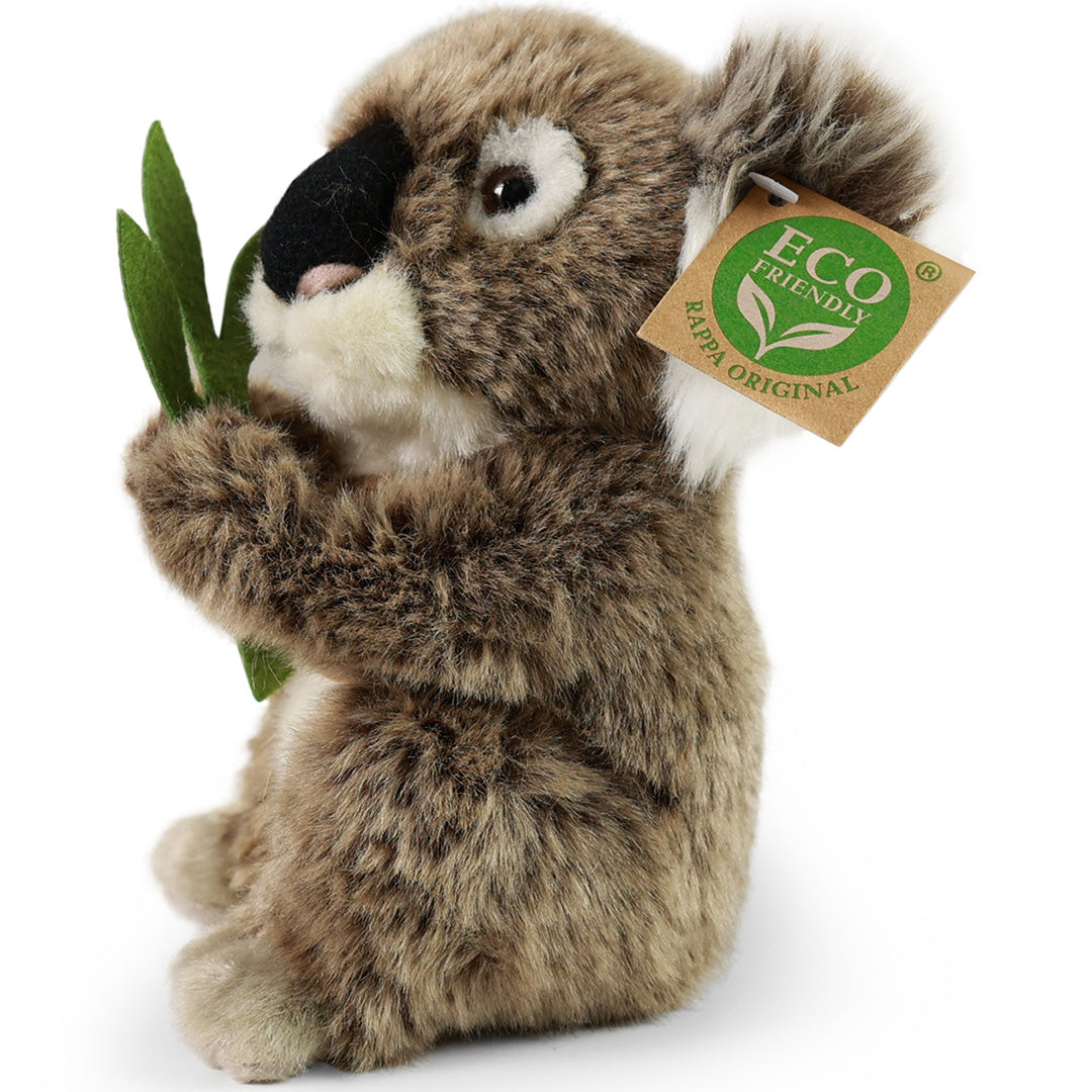 Een Rappa pluchen koala knuffel zit schuin, met een groen takje in zijn pootjes.