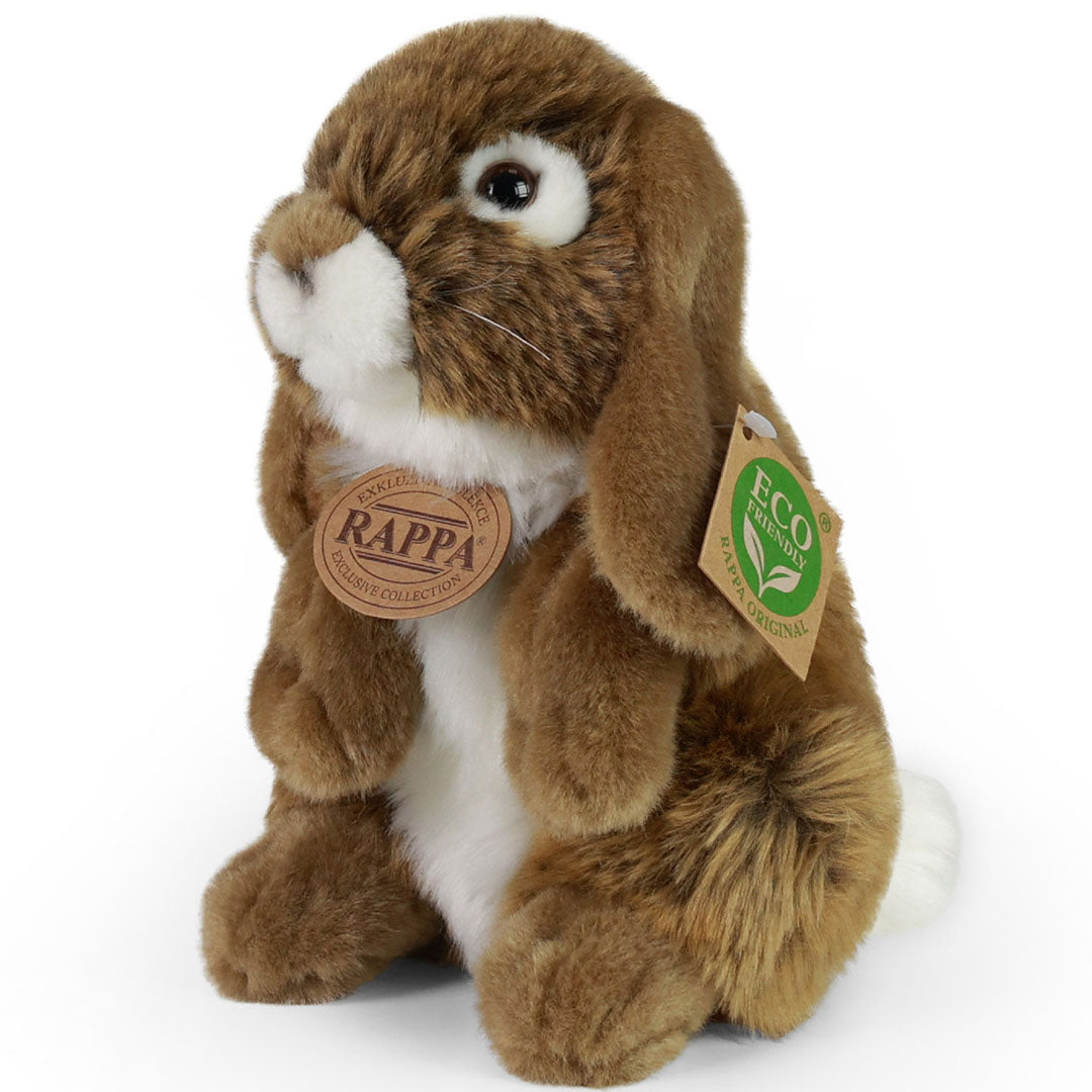 Rappa pluchen konijn, bruin met witte buik en staart, zittend en schuin van voren gefotografeerd.