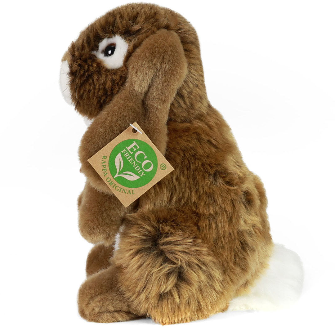 Rappa pluchen konijn, bruin met witte staart, zittend en van de zijkant gefotografeerd.