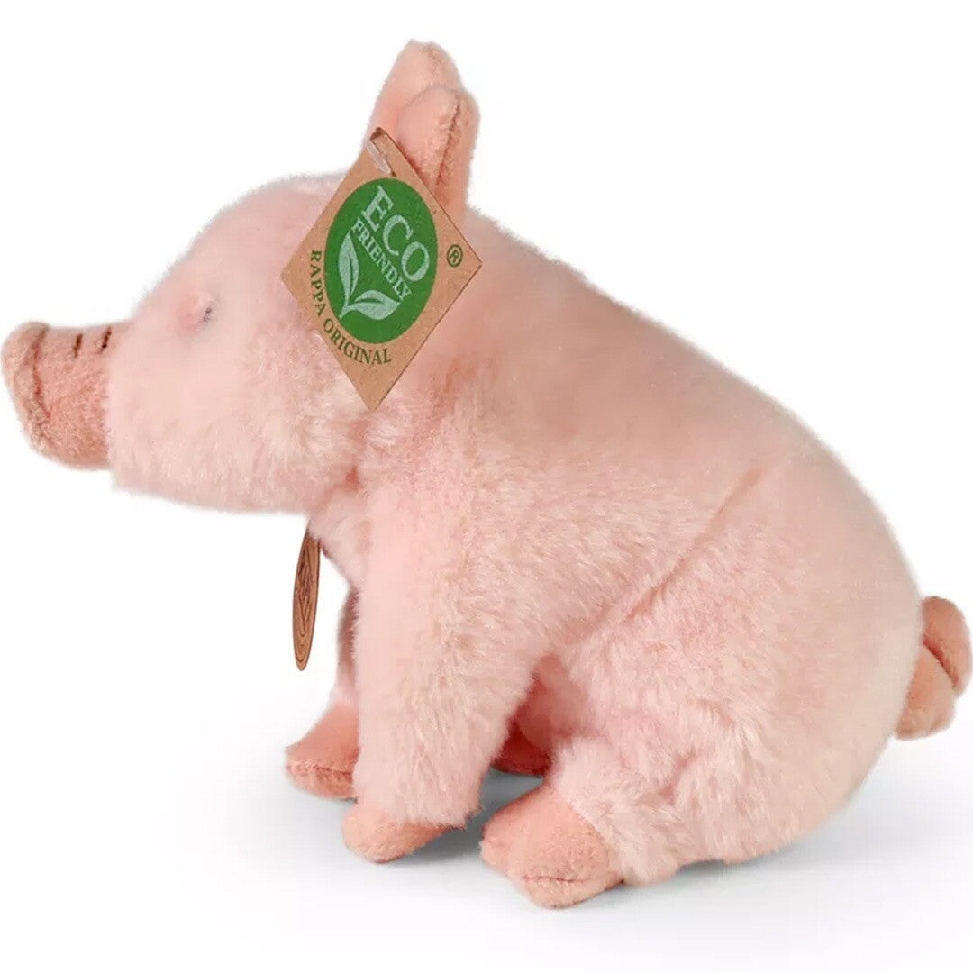 Rappa roze pluchen varken knuffel, zittend en van de linkerkant gefotografeerd.