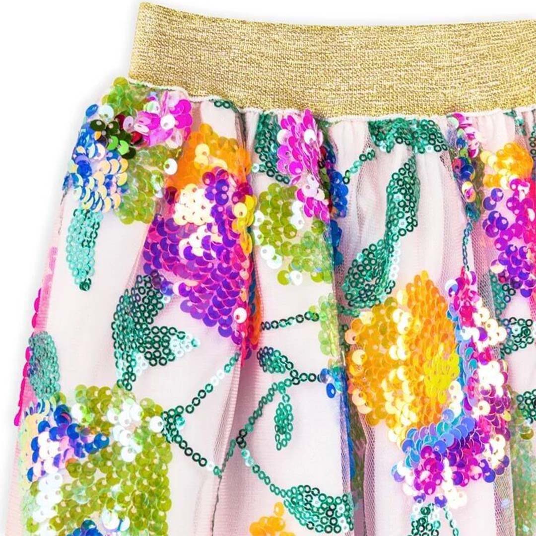 Close-up van de ratatam kinderrok met gouden tailleband en gebloemd sequinpatroon.