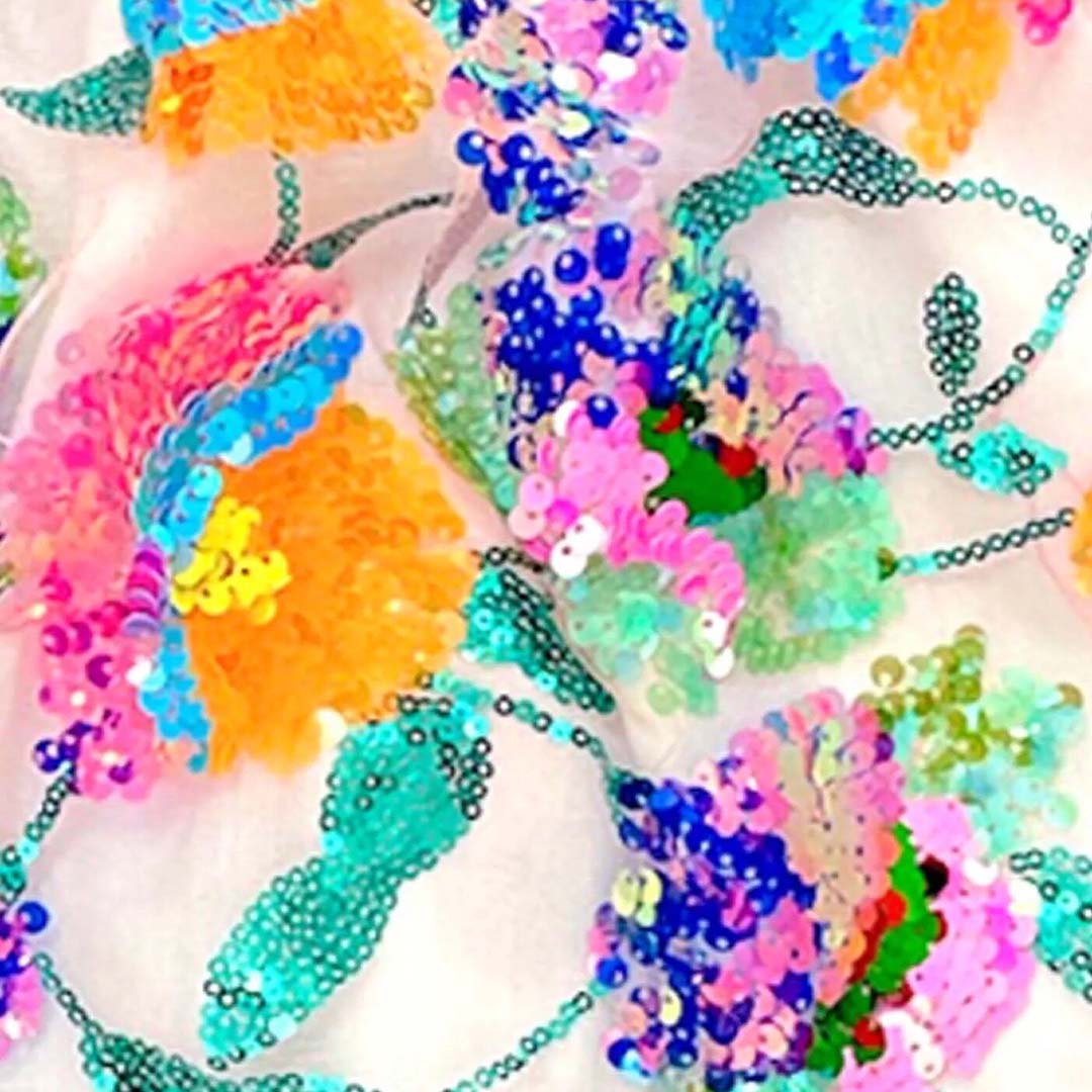 Detail van de veelkleurige sequins die een gebloemd patroon vormen op de kinderrok.