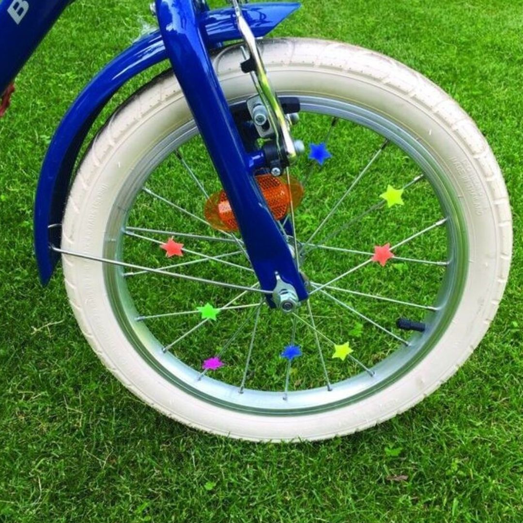Veelkleurige bliksem spaakdecoratie bevestigd aan de spaken van een blauw fietswiel.