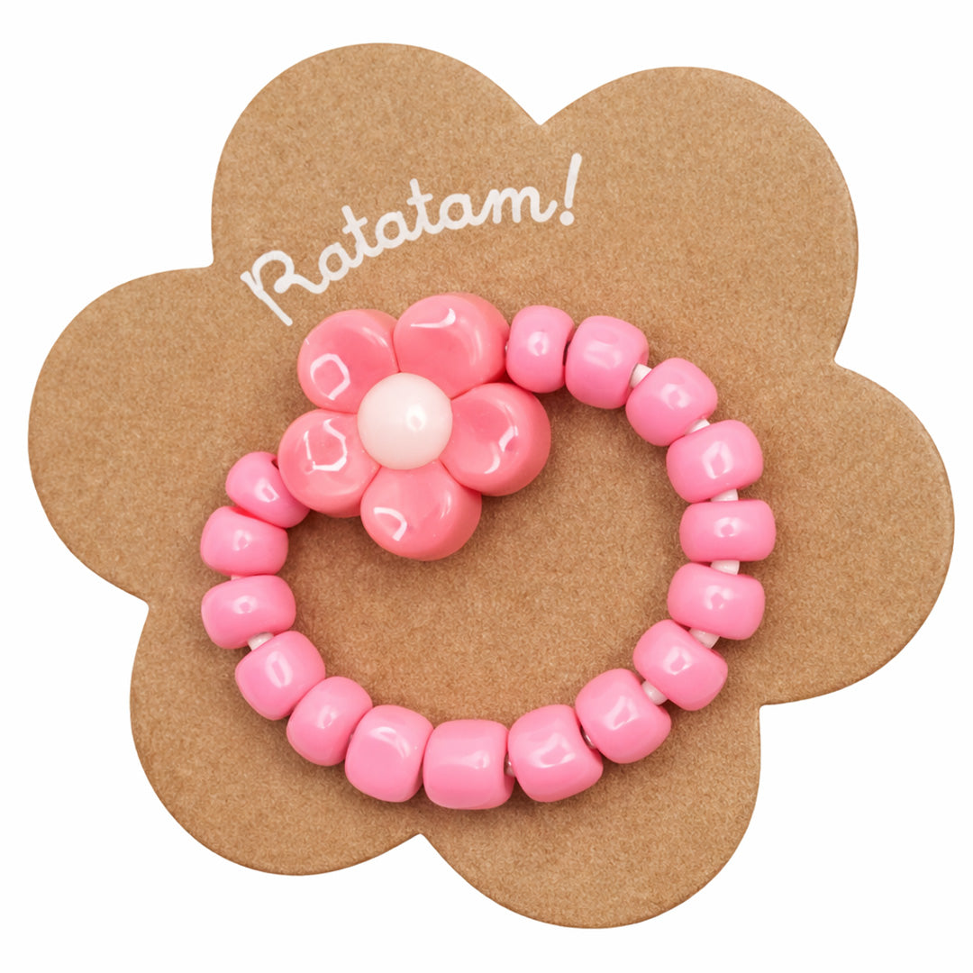 Ratatam kinderring met roze kralen en een bloem op een bloemvormige verpakking.